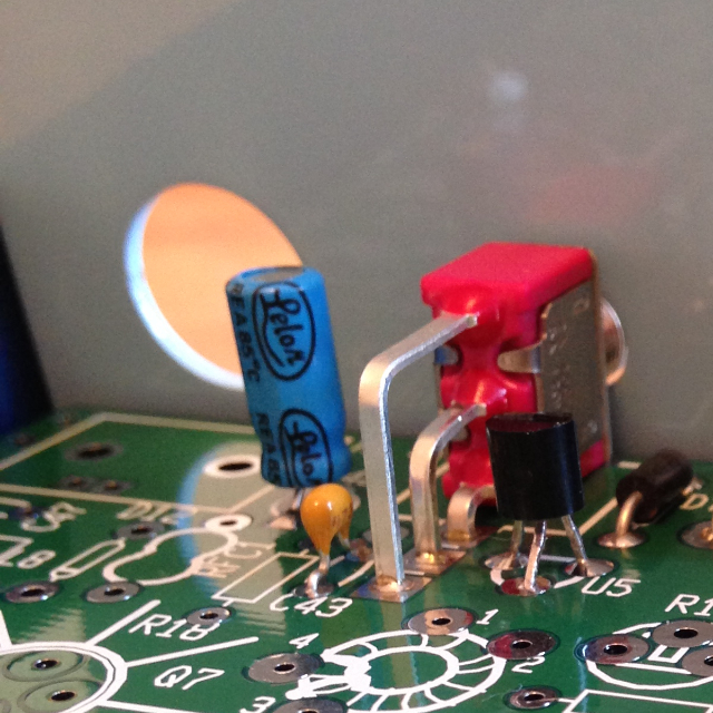 An overhead view of the single pole double throw on/off switch in the NorCal 40A transceiver, showing the three solder pads that attach the switch to the circuit board.